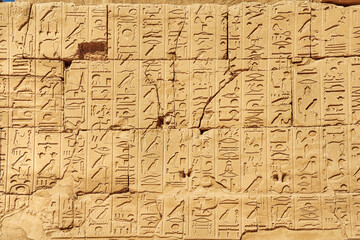 Obraz premium Ancient Egyptian wall with large hieroglyphs. Karnak Hypostyle hall columns in the temple at Luxor Thebes