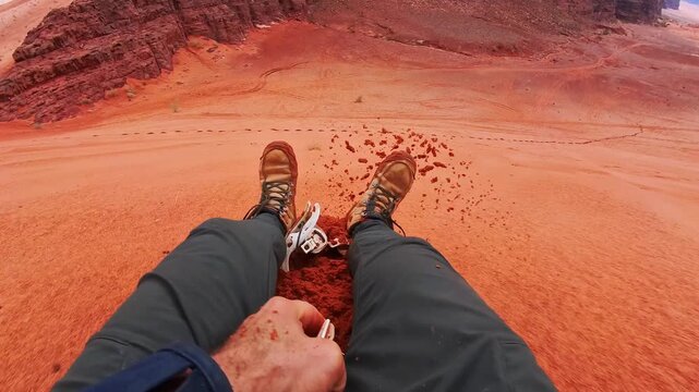 Rider pov Sand boarding from red dune Wadi Rum Jordan, traveler POV with board, desert adventure freedom concept. Wadi rum tours and Sand boarding, hiking, wandering outdoors activities