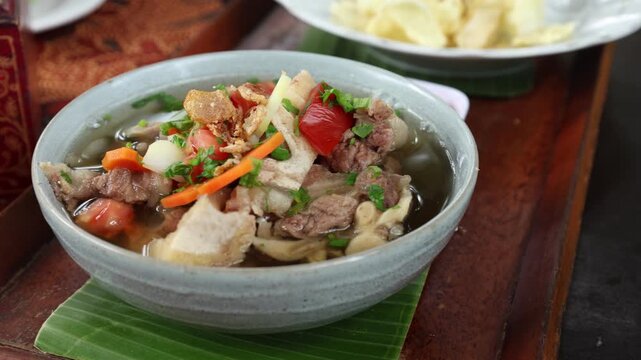 Oxtail soup (sop buntut). Made from pieces of beef tail that are seasoned then put in a slightly beef broth with sliced potatoes, carrots, tomatoes, celery. Indonesian traditional culinary
