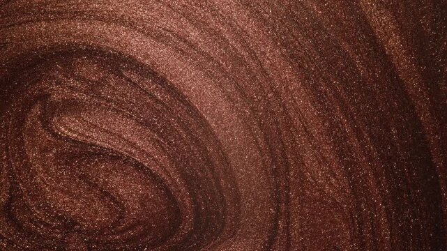 Detailed rotating close-up of dark copper paint displaying specialized sandy texture and radiant glitter particles swirling on surface