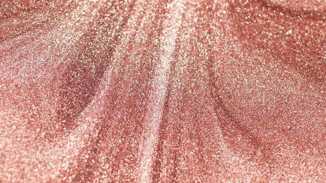 Close-up of rose gold paint with a specialized sandy texture rotating slowly and shimmering with radiant glitter particles
