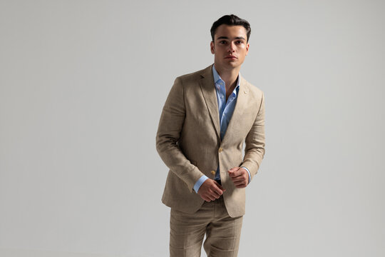 Confident man in beige suit posing