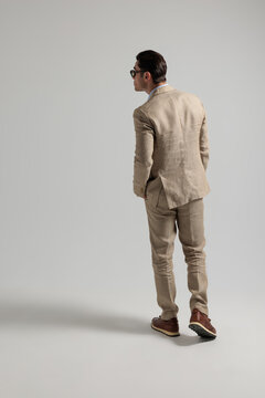 Rear view of elegant man walking away looking to side