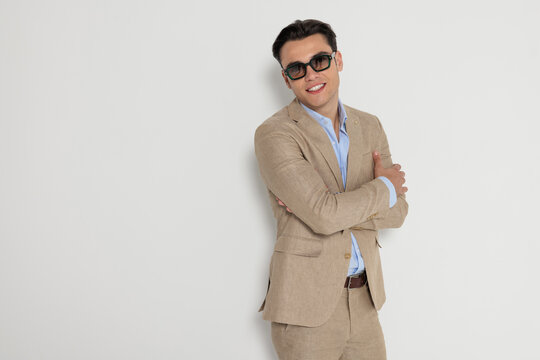 Cheerful man with crossed arms wearing sunglasses
