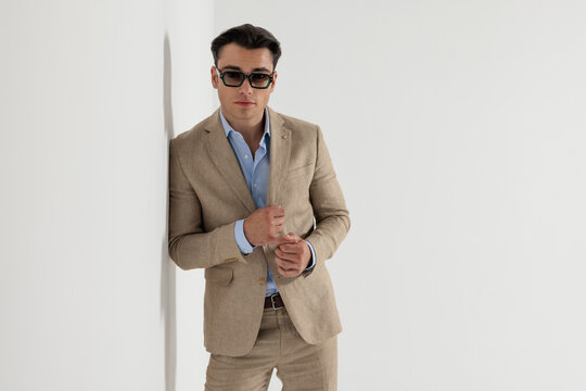 Fashion man rubbing hands together while leaning