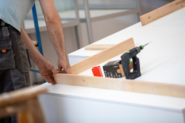 Menuisier exp&eacute;riment&eacute;, habile et comp&eacute;tent, en train de monter un meuble sur-mesure. Concept de menuiserie et de fabrication de meubles &agrave; faire soi-m&ecirc;me.