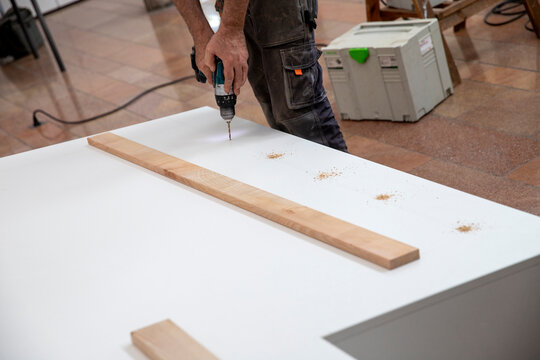 Menuisier exp&eacute;riment&eacute;, habile et comp&eacute;tent, per&ccedil;ant des trou sur un meuble sur-mesure. Concept de menuiserie et de fabrication de meubles &agrave; faire soi-m&ecirc;me.