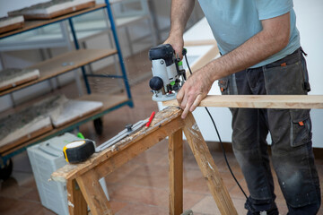Menuisier travaillant avec une scie sauteuse à l'intérieur d'un bâtiment. Ouvrier sciant une...