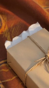 Rustic gift box tied with string on a warm blanket