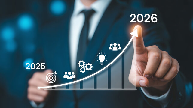 Business professional points to a rising graph indicating growth towards the year 2026.