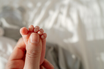 Infant feet detail in cozy home setting. Perfect visual for parenting blogs, baby care advertising...