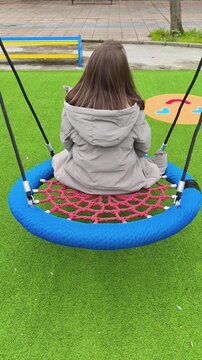 Mujer sola balance&aacute;ndose en columpio de parque, reflejo de soledad y ausencia de hijos