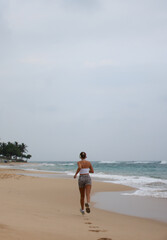 Runner On Beach. Dedicated Athlete Practices Endurance By Jogging Solitary Along Tranquil Ocean Coast