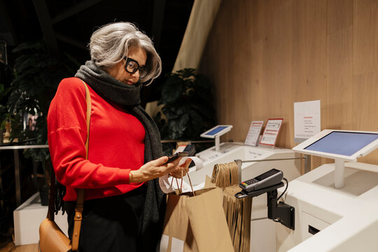 Fashionable customer with gray hair shopping in modern retail store