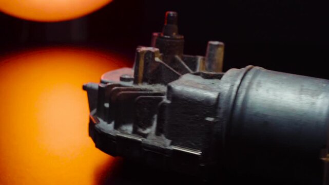 old car wiper motor for windshield cleaning, repair at the service, shooting in a dark room, red light illumination