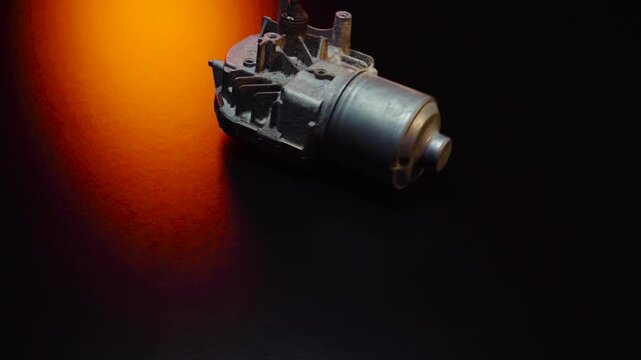 old car wiper motor for windshield cleaning, repair at the service, shooting in a dark room, red light illumination