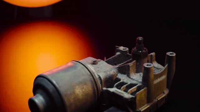 old car wiper motor for windshield cleaning, repair at the service, shooting in a dark room, red light illumination