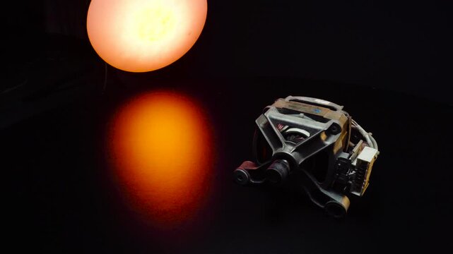 creative long exposure photography old electric motor from a washing machine, automatic repair at the service, shooting in a dark room, backlighting with red light