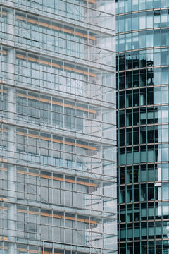 Modern glass building facade with reflections and linear grid lines creating abstract architectural pattern in urban design
