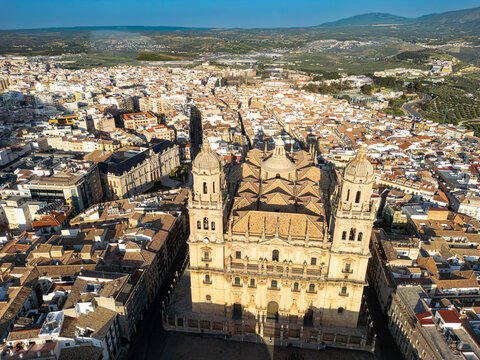 Aerial view of the majestic Jaen Cathedral casts long shadows over the city's terracotta rooftops, a blend of history and urban life, Jaen, Andalucia, Spain.