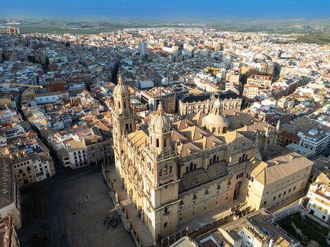 Aerial view of the Jaen Cathedral standing majestically amidst the urban tapestry, its golden facade glowing in the warm light, Jaen, Andalucia, Spain.