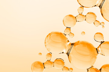 Abstract golden oil molecules floating on warm background. 3D render of luxury cosmetic serum or vitamin liquid with glossy transparent spheres, molecular structure, and copy space.