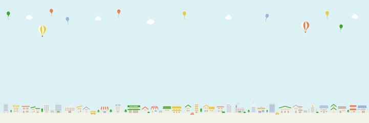 空にコピースペースのある街並み風景　 風船と雲の横長イラスト