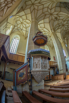 BIERTAN,ROMANIA-SEPT. 3, 2021: Interior of the fortified evangelical church built 1490-1520.The polyptych altar, with 28 painted panels, was made in 1483 and 1513.The pulpit carved in stone,from 1500.