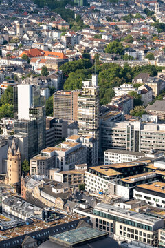 Daytime aerial view shows the urban skyline with highrise architecture across the central district of Frankfurt Germany in a dense city scene