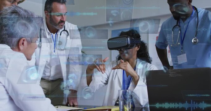 Doctor putting on VR and manipulating holo medical charts using hands while team monitoring