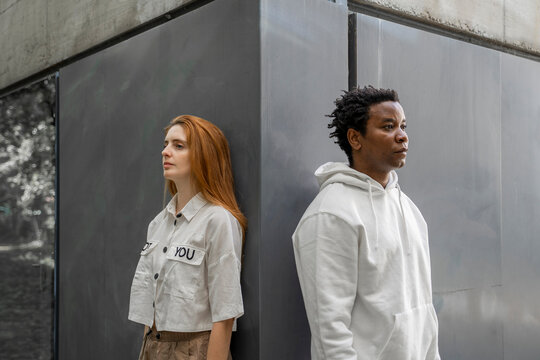 Portrait of a man and a woman leaning on a wall