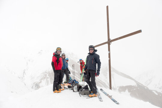 Georgia, Caucasus, Gudauri, peeope at summit cross on a ski tour