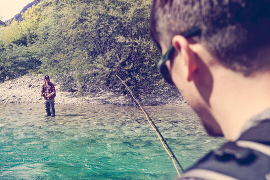 Slovenia, two men fly fishing in Soca river