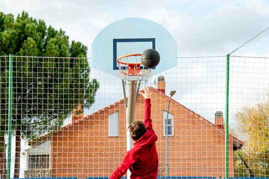 Teenager playing basketball, dunking