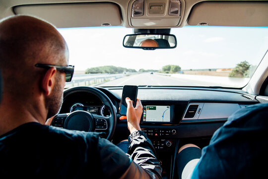 Man sitting in a car using his smartphone