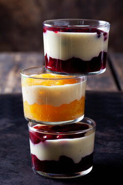 Red and yellow fruit compote with vanilla sauce layered in glasses
