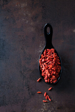 Spoon of dried wolfberries on rusty metal