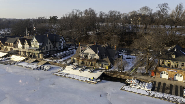 Aerial view of the Boathouse Row along the Schuylkill River, its reflections shimmering on the icy surface, juxtaposed against the bare trees, Philadelphia, Pennsylvania, United States.