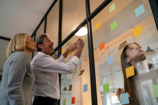 Businessman and businesswoman with mischievous girl in office