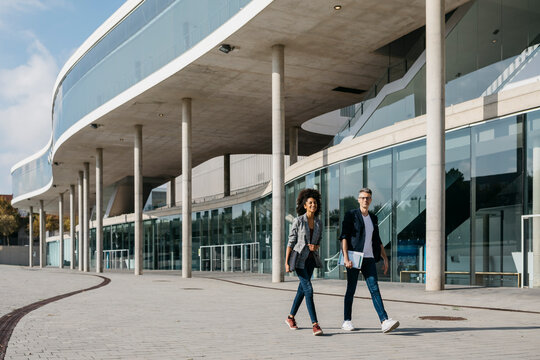 Two colleagues walking outside office building