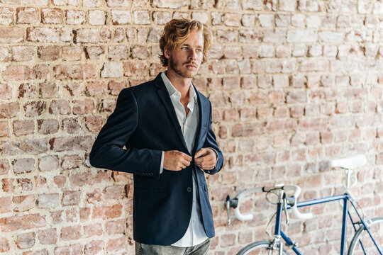 Businessman buttoning jacket