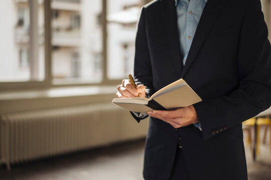 Businessman using timetable in the office, partial view