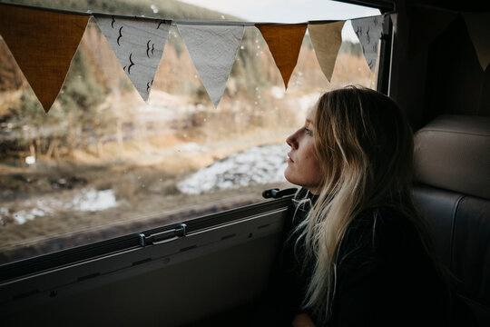 Pensive young woman looking out of car window