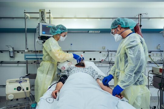 Doctors caring for patient in emergency care unit of a hospital changing breathing from oxygen mask to bag valve mask