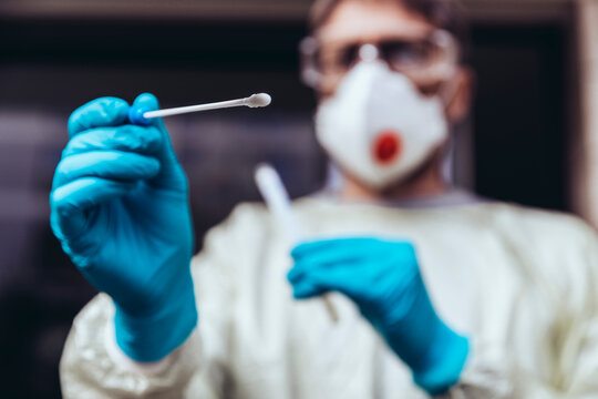 Healthcare worker holding swab test kit for PCR testing