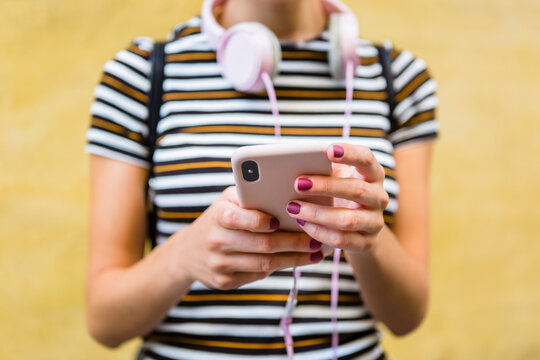 Hands of woman holding smartphone, close-up