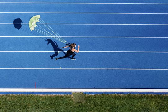 Top view of female runner with parachute on tartan track