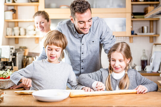 Family preparing baguette in kitchen