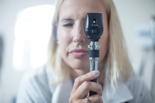 Female pedeatrician using a otoscope