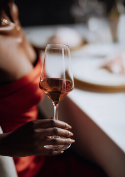 Elegant fine dining: close-up of woman in red dress holding wine glass for luxury lifestyle and hospitality themes.
A sophisticated and alluring detail shot of a celebratory moment